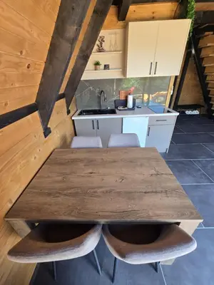 a kitchen with a wooden table and chairs at JAGI Bungalovi Mrkonjic Grad in Mrkonjić Grad