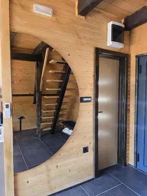 a room with a spiral staircase in a wooden wall at JAGI Bungalovi Mrkonjic Grad in Mrkonjić Grad