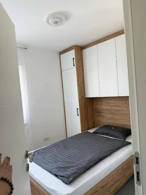 a small bedroom with a bed with white cabinets at Bella LUX in Modriča