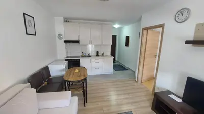 a kitchen and living room with a table and a couch at Apartman Mario in Tomislavgrad