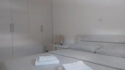 two beds in a white room with towels on them at Apartman Mario in Tomislavgrad