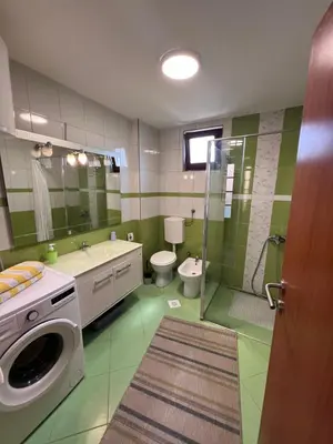 a bathroom with a washing machine and a toilet at Apartmani Odmor Fojnica in Fojnica