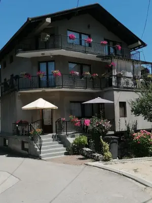 a building with balconies and tables and umbrellas at Apartmani Odmor Fojnica in Fojnica