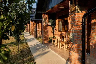 a brick building with a table and chairs on a sidewalk at Etno Camp Lucić in Odžak