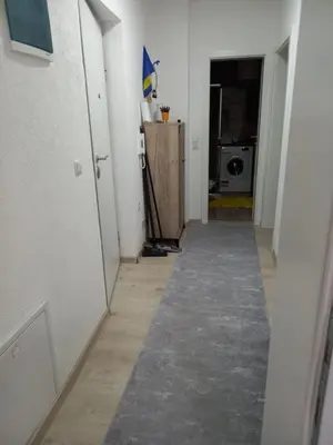 a hallway leading to a room with a carpet on the floor at Stan Živinice bb in Živinice