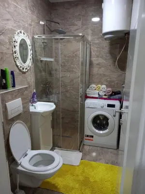 a bathroom with a toilet and a washing machine at Stan Živinice bb in Živinice