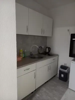 a kitchen with white cabinets and a sink at Stan Živinice bb in Živinice