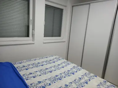 a bedroom with a bed with a blue and white blanket at Stan Živinice bb in Živinice