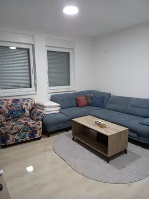 a living room with a blue couch and a coffee table at Stan Živinice bb in Živinice