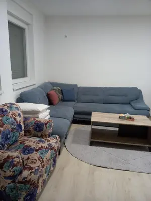 a living room with a blue couch and a coffee table at Stan Živinice bb in Živinice