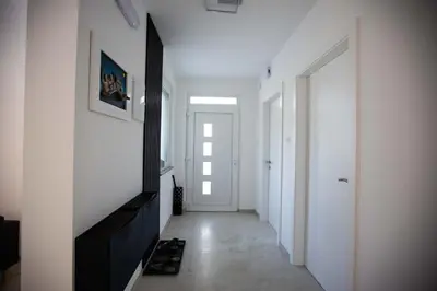 a hallway with white walls and a white door at Villa Ena in Praščijak