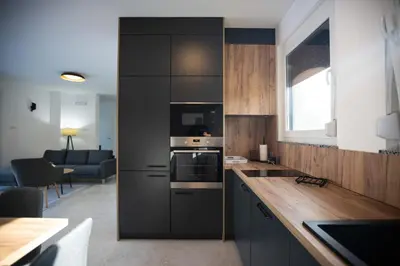 a kitchen with black cabinets and a living room at Villa Ena in Praščijak