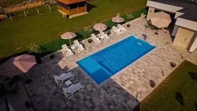 an overhead view of a pool with chairs and umbrellas at Villa Ena in Praščijak