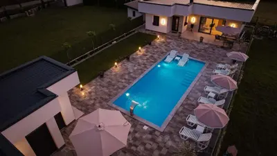 an overhead view of a swimming pool with chairs and umbrellas at Villa Ena in Praščijak