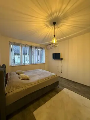 a bedroom with a large bed and a chandelier at Apartman EM Bugojno in Bugojno