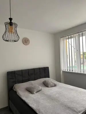 a bed with two pillows in a bedroom with a window at Apartman EM Bugojno in Bugojno
