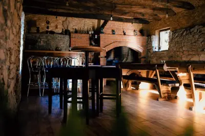 a dining room with a table and chairs and a fireplace at Kuca za odmor Lovric