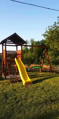 a playground with a yellow slide and a gazebo at Kuca za odmor Lovric