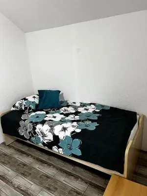 a bed with a black blanket with flowers on it at Villa Melek in Bihać