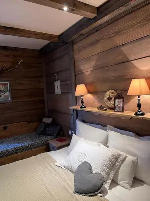 a bedroom with a bed with a wooden wall at Runolist Kupres in Kupres