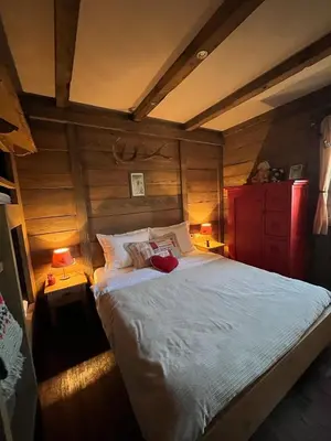 a bedroom with a large bed in a room with wooden walls at Runolist Kupres in Kupres