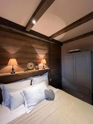 a bedroom with a large bed with a wooden headboard at Runolist Kupres in Kupres