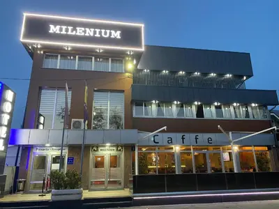 a building with a lit up sign on top of it at Hotel New Milenium in Lukavac