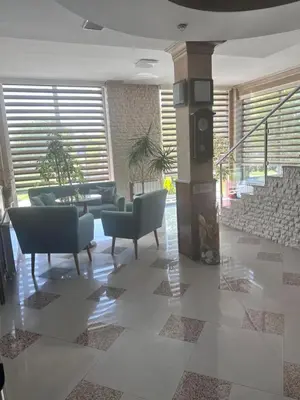a living room with couches and chairs and a staircase at Hotel New Milenium in Lukavac