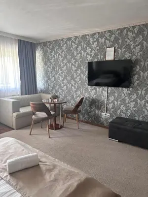 a bedroom with a living room with a couch and a table at Hotel New Milenium in Lukavac