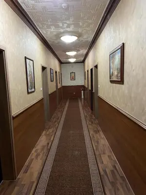 a hallway in a building with wooden floors and ceilings at Hotel New Milenium in Lukavac