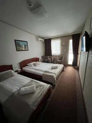 a hotel room with two beds and a television at Hotel New Milenium in Lukavac