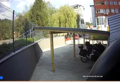 a motorcycle parked under a canopy on a parking lot at Hotel New Milenium in Lukavac