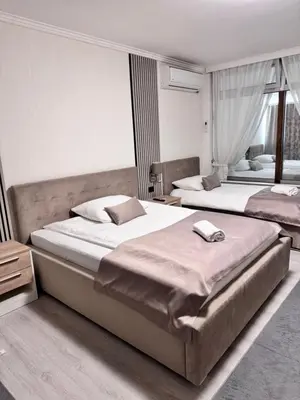 two beds in a hotel room with two beds at Hotel New Milenium in Lukavac