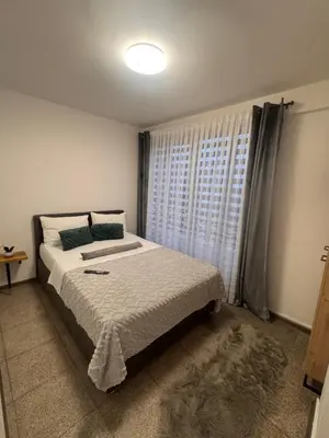 a bedroom with a large bed and a window at Apartman Booem in Bihać