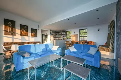 a living room with blue couches and a table at Vila Natalijina Ramonda in Banja Luka