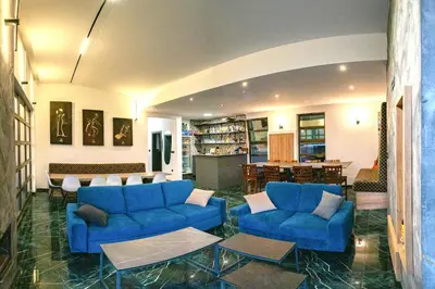 a living room with blue couches and a table at Vila Natalijina Ramonda in Banja Luka