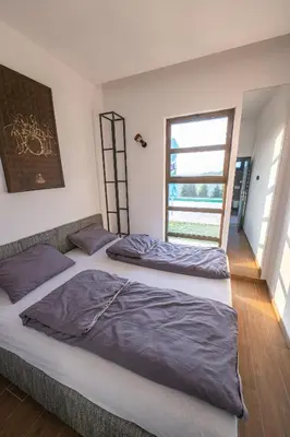 two beds in a room with a window at Vila Natalijina Ramonda in Banja Luka