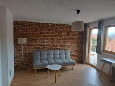 a living room with a couch and a brick wall at Guest House Puccallpah in Visoko