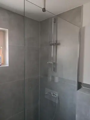 a shower with a glass door in a bathroom at Guest House Puccallpah in Visoko