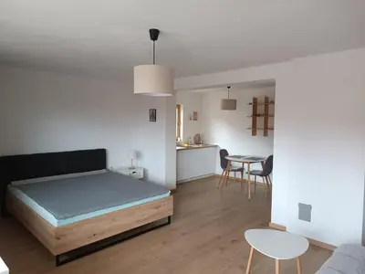 a bedroom with a bed and a table and chairs at Guest House Puccallpah in Visoko