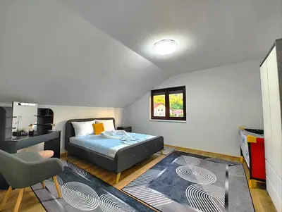 a bedroom with a bed and a desk and a chair at Apartman Una Paradies in Bihać