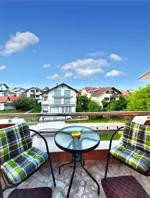 a balcony with two chairs and a glass table at Apartman Una Paradies in Bihać