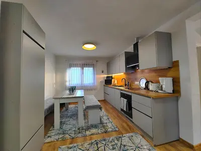 a small kitchen with a table and a desk at Apartman Una Paradies in Bihać