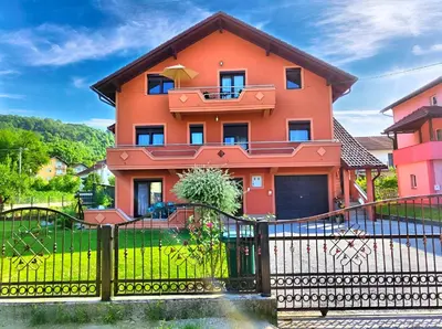 a orange house with a black fence at Apartman Una Paradies in Bihać