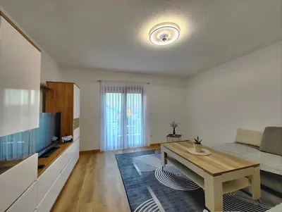 a living room with a table and a couch at Apartman Una Paradies in Bihać