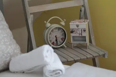 a clock sitting on a chair in a bedroom at Holiday Home Tunnel Ravne in Visoko
