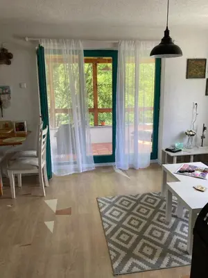 a living room with a table and a dining room with a window at Holiday Home Tunnel Ravne in Visoko