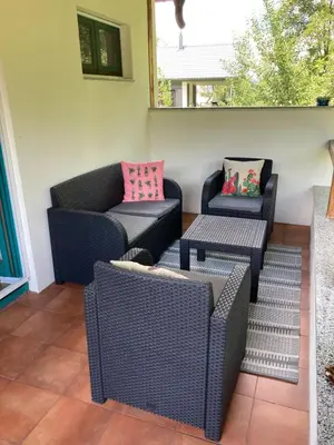 a patio with two wicker chairs and a table at Holiday Home Tunnel Ravne in Visoko