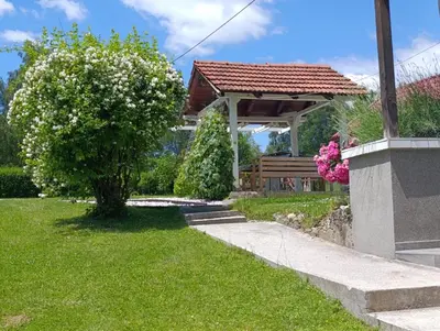 a gazebo with a bench in a yard at Holiday Home Tunnel Ravne in Visoko