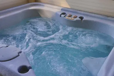 a jacuzzi tub filled with blue water at Tiny House Ljiljan in Bihać